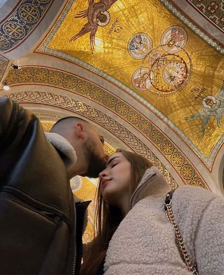 A couple beneath a gold mosaic dome