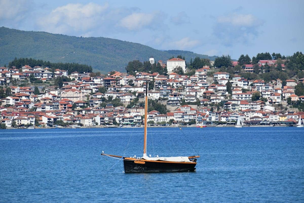 The old town of Ohrid rising above Lake Ohrid, with a boat moored offshore